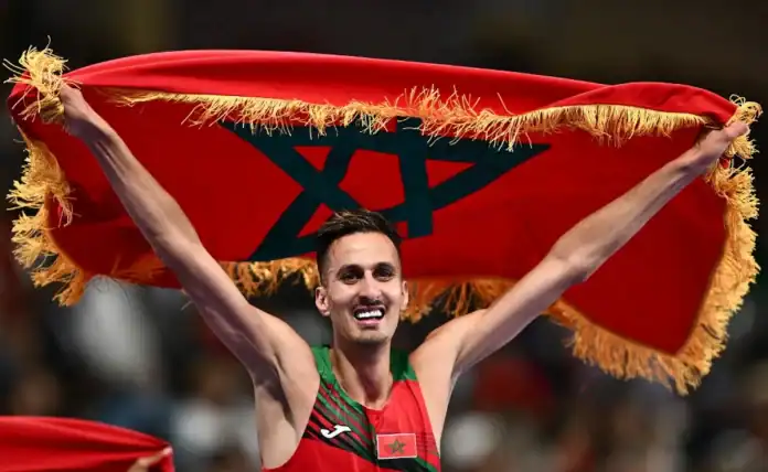 سفيان البقالي يحتفل بعد فوزه في نهائي سباق 3000 متر حواجز.
